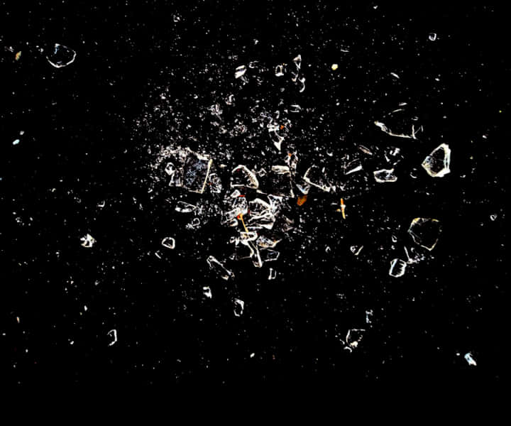 Shattered_ Glass_ Fragments_ Against_ Black_ Background.jpg