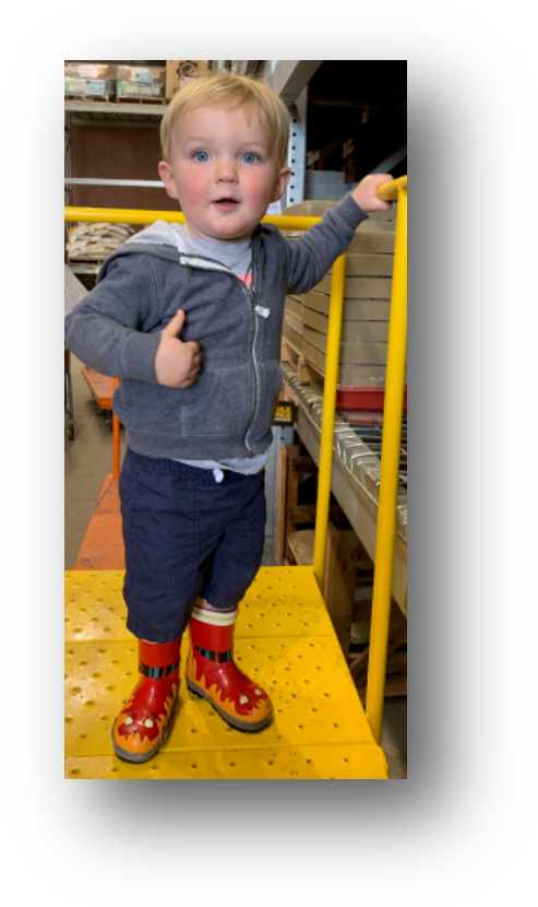 Toddler In Warehouse With Boots