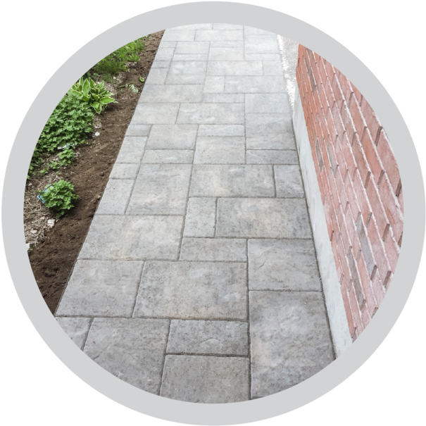 Paved Cobblestone Pathway Nextto Brick Wall PNG Image